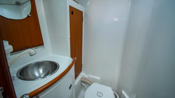 Das Badezimmer der Viktoria II ist mit einem kompakten Waschbecken, einer Toilette und einem Spiegelschrank ausgestattet