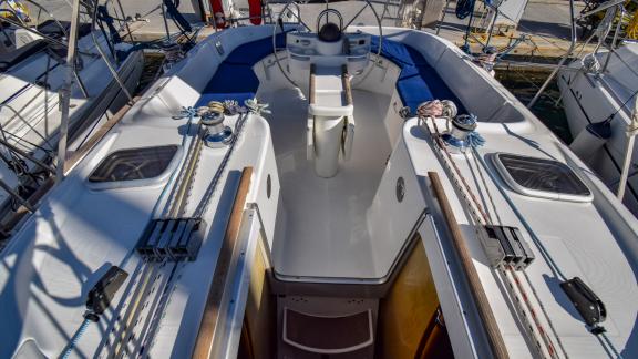 Helm and cockpit seating area with blue cushions on the sailing yacht Burda, surrounded by ropes and winches.