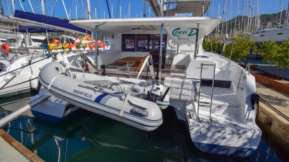 The aft deck of the Coco D catamaran features an inflatable dinghy and a comfortable seating area.