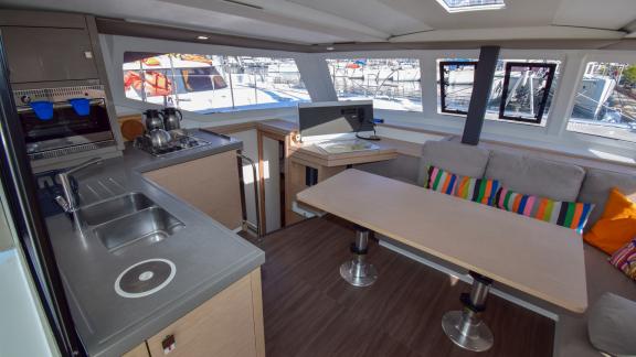 The salon of catamaran Coco D offers a modern living space with a comfortable seating area and a fully equipped kitchen.