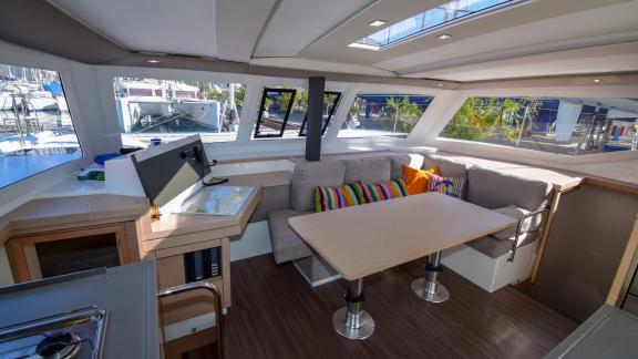 The saloon of catamaran Coco D offers a comfortable seating area and a bright atmosphere with large windows.