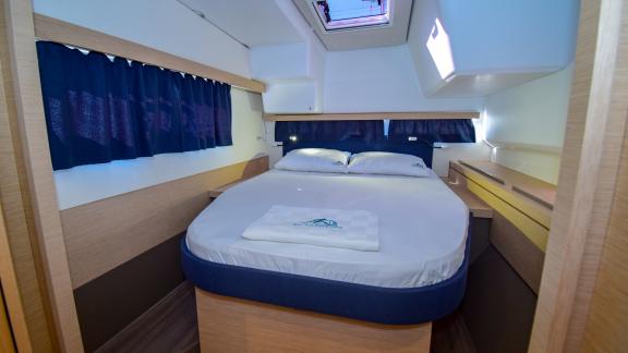 The double cabin of catamaran Coco D offers a spacious bed and modern decor for a relaxing stay.