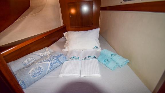 The comfortable cabin of the catamaran The Big Easy is equipped with a cozy bed and soft linens.