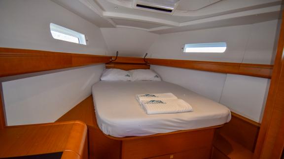 Double cabin with a large bed and two portholes