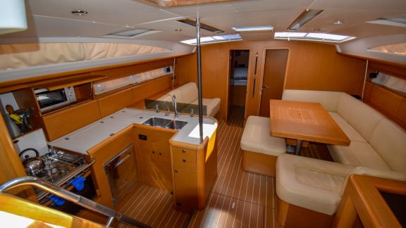 The spacious and bright saloon of the yacht Instant Zero offers a modern seating area and kitchen.