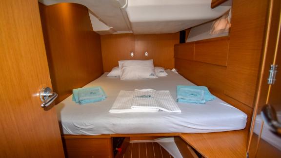 The double cabin of the yacht Instant Zero offers clean towels and a comfortable bed.