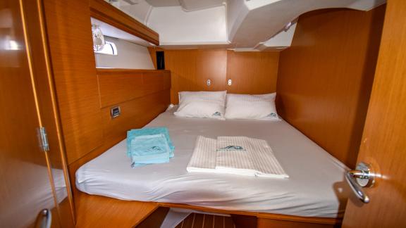 The cabin of the yacht Instant Zero features a wide bed with fresh linens and towels.