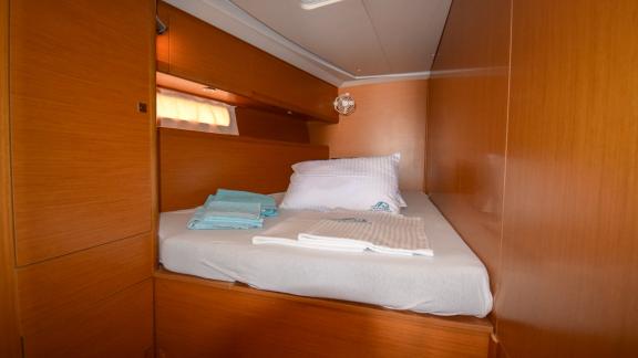 The cabin of the yacht Instant Zero offers a warm atmosphere with a simple design and a comfortable bed.