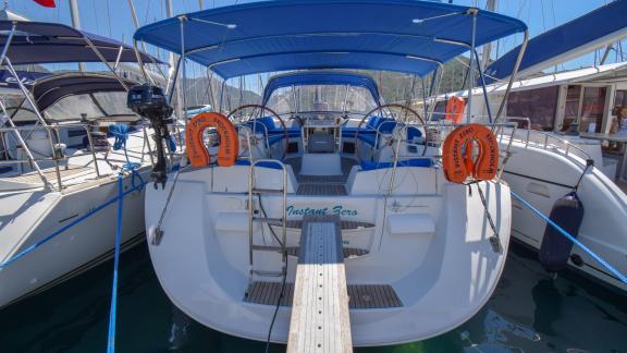 The aft deck of the yacht Instant Zero features a spacious seating area under a blue canopy.