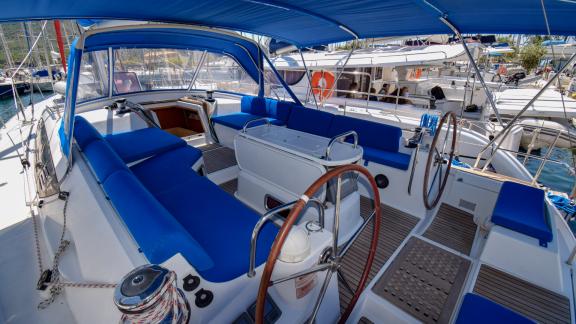 The spacious cockpit of the yacht Instant Zero with blue cushions offers a comfortable seating area.