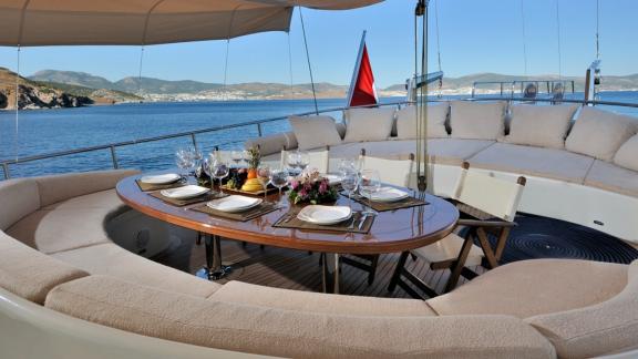 Spacious sitting area with two semi-circular sofas and a table for a large group of guests