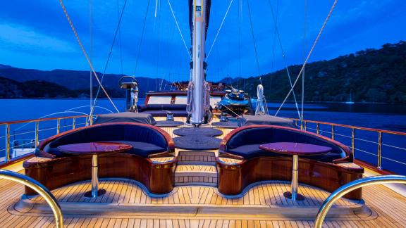 Gemütliche Lounge-Bereiche auf dem Deck der SY Voyage bei Abenddämmerung mit herrlichem Ausblick.