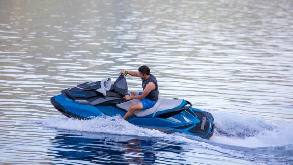 Ein Gast genießt eine aufregende Jet-Ski-Fahrt auf dem klaren Wasser in der Nähe der SY Voyage.