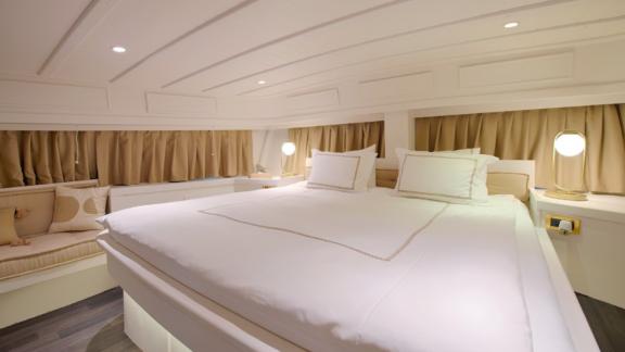 The master cabin on Liberte 11 offers a comfortable atmosphere with a large bed and modern lighting.