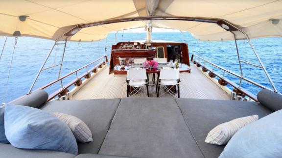 The aft deck of Gulet Liberte 11 features an elegant dining area with sea view and comfortable sun loungers.