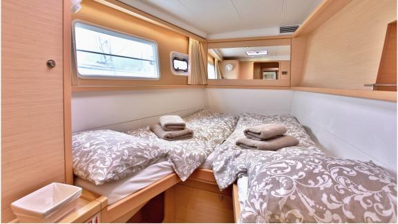 Stilvoll eingerichtete Kabine mit Doppelbett und warmen Holztönen an Bord des Katamarans Marla Lagoon 450F.