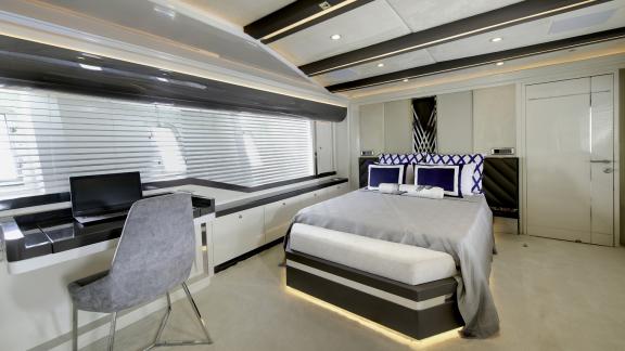 Stilvolle und komfortable Kabine auf der Yacht Vetro, ausgestattet mit Schreibtisch und luxuriösem Bett.