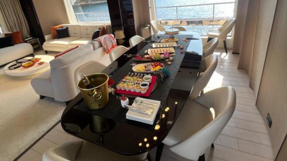 Inside yacht Nino, a stylish dining table and comfortable seating area with sea views.