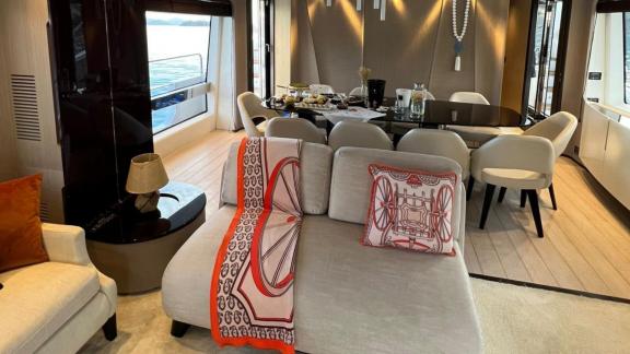 Inside yacht Nino, a comfortable seating area and stylish dining table with sea views.