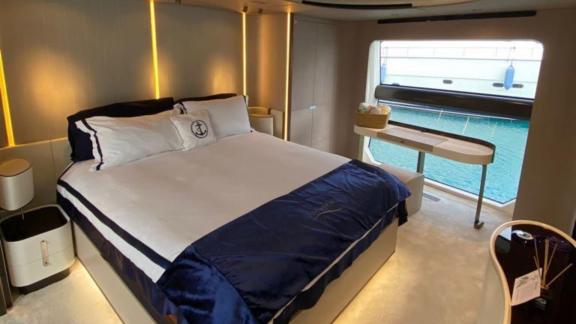 Bedroom on the yacht Nino with modern design, a large bed, and a window with a sea view.