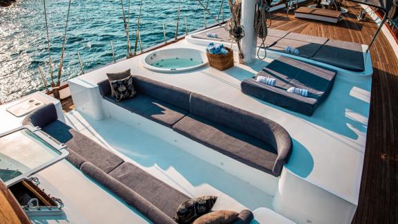 Sun deck of a motorised sailing boat in Fethiye with comfortable loungers and a whirlpool.