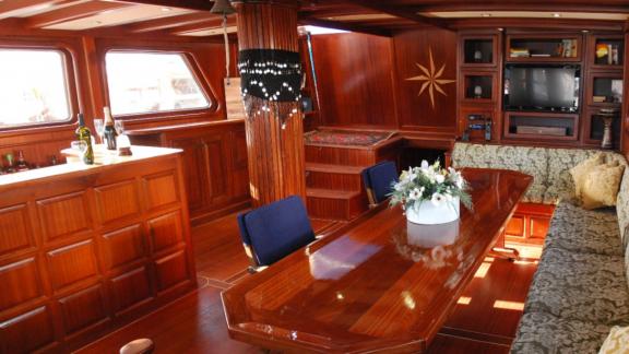 Der elegante Salon der Gulet Sahinoğlu bietet einen großen Esstisch, eine Bar und komfortable Sitzgelegenheiten.