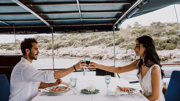 Couple enjoying a romantic dinner aboard the Gulet Capricorn 1 with scenic views.