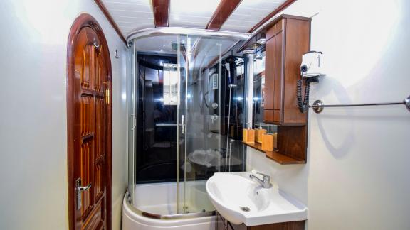 A modern bathroom on the gulet 'Ugur' with a spacious shower cubicle and elegant wood panelling.