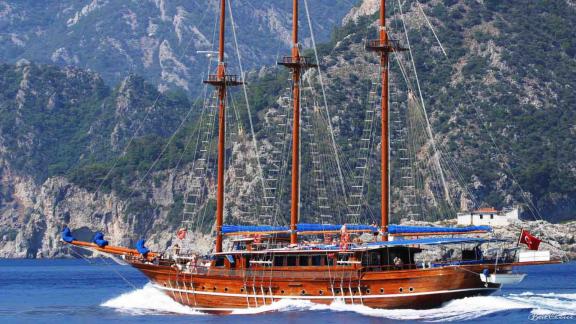 Gulet with 8 cabins, wooden hull and three high masts, sailing off the coast of Marmaris.