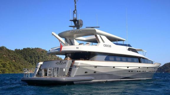 The luxury yacht Crocus stands in the middle of the sea during the day, the deck is empty.