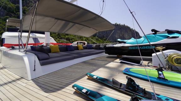 Comfortable sofa for lounging and sunbathing on the upper deck.  You can see the equipment for water entertainment