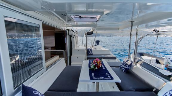 The aft deck of catamaran Deniz3 offers a seating area with sea views and comfortable cushions.