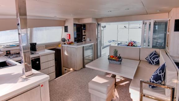 The saloon of catamaran Deniz3 offers a comfortable setting with cozy seating and a modern kitchen.