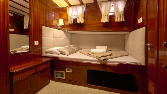 Büyük bir çift kişilik yatak içeren yatak odası. Depolama alanını ve aynayı görebilirsiniz