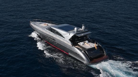 Die Motoryacht Zazzazu gleitet durch das Meer bei Ibiza. Am Heck lädt ein Sonnendeck zum Genießen ein.