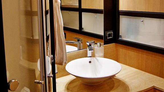 On Noi Quattro in Trogir, round sink, mirror, shower and wood vanity are visible for private yacht hire.