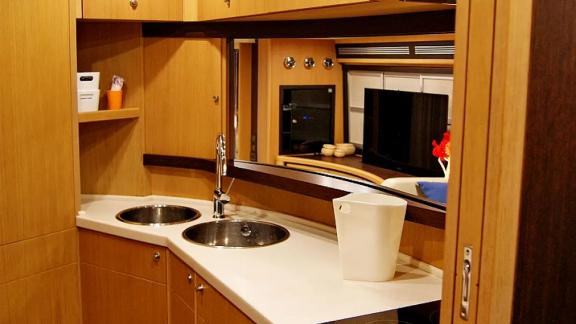 On Noi Quattro in Trogir, the galley, twin sink, counter and mirror are visible for private yacht charter.