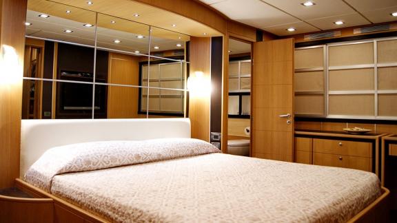 On Noi Quattro in Trogir, the double bed, mirrored wall, door and warm cabin lights are seen for yacht hire.