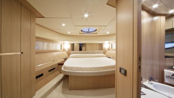 On Sea Side in Trogir, the master cabin shows a double bed, wood panels, ceiling lights and sink for weekly hire.
