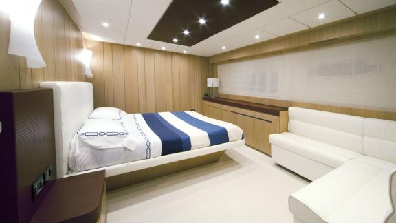 On Sea Side in Trogir, the guest cabin shows a double bed, white sofa, lamps and wood walls for weekly charter.