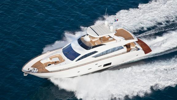 Near Trogir, Sea Side motor yacht speeds over blue sea with white wake, flybridge and bow lounge for weekly hire.