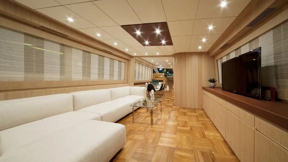 Aboard charter yacht Sea Side in Trogir, the saloon shows a white sofa, glass table, TV and wood floor.