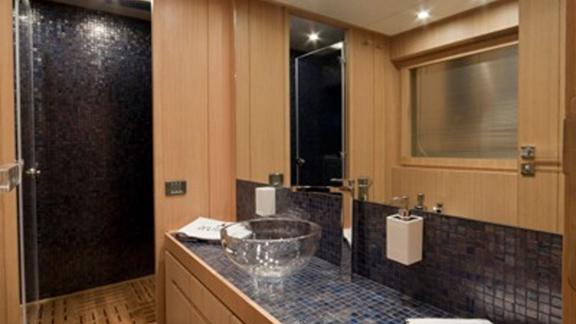 On Sea Side in Trogir, the bathroom shows a glass sink, mosaic counter, shower and wood finish for weekly hire.