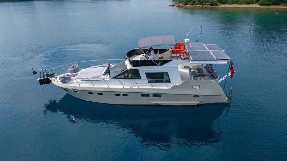 Motor yacht Ada Kuzey preparing to anchor in a tranquil bay, offering a splendid view.