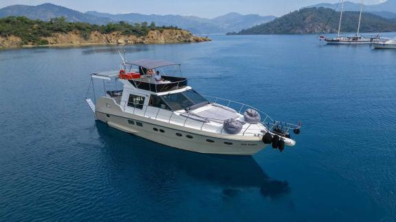 Motor yacht Ada Kuzey anchoring in a picturesque bay.