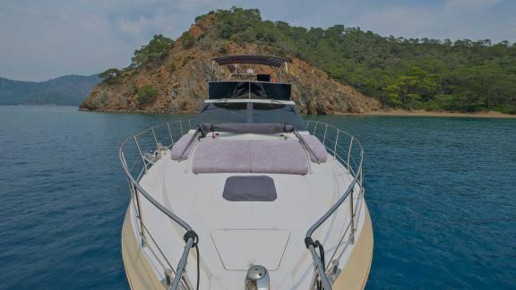 The foredeck of motor yacht Ada Kuzey anchored in a calm bay.