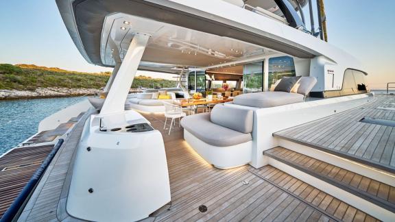 Spacious lounge and dining areas on the deck of Lagoon Seventy 7 with coastal views.