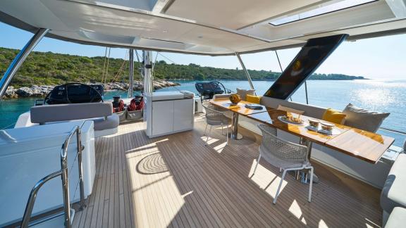 Luxurious dining area on the flybridge of Lagoon Seventy 7 with a view of the sea.