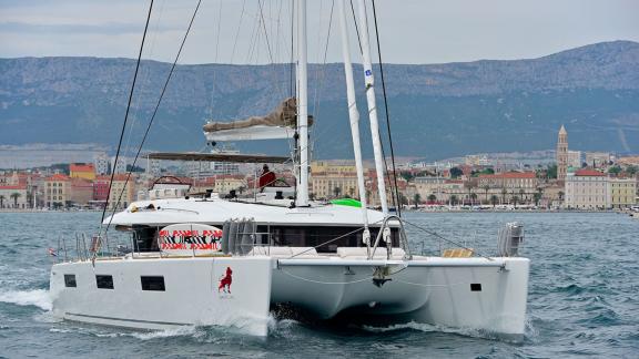 Lagoon 620 Adriatic Lion in motion with the city of Split and mountains in the background