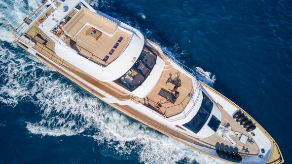 Spacious deck of the motor yacht Wide Liberty with sun loungers and fitness equipment on the open sea.